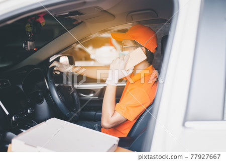 Delivery man employee driving car and using mobile phone during coronavirus pandemic situation Delivery man employee driving car and using mobile phone during coronavirus pandemic situation 77927667