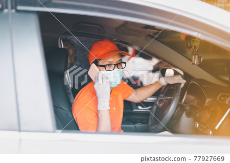Delivery man employee driving car and using mobile phone during coronavirus pandemic situation Delivery man employee driving car and using mobile phone during coronavirus pandemic situation 77927669