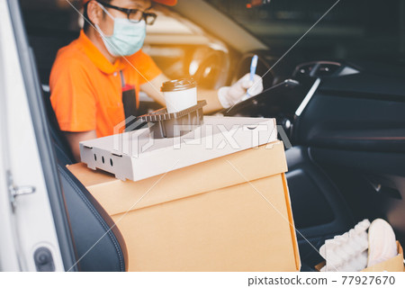 Delivery man employee checking list order online in car for customer during coronavirus pandemic situation Delivery man employee checking list order online in car for customer during coronavirus pandemic situation 77927670