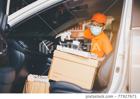 Delivery man employee checking list order online in car for customer during coronavirus pandemic situation Delivery man employee checking list order online in car for customer during coronavirus pandemic situation 77927671