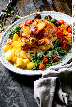 Grilled cooked whole chicken with grilled bell pepper and potatoes Grilled cooked whole chicken with grilled bell pepper and potatoes 77927799