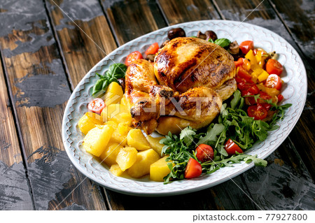 Grilled cooked whole chicken with grilled bell pepper and potatoes 77927800