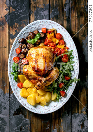 Grilled cooked whole chicken with grilled bell pepper and potatoes Grilled cooked whole chicken with grilled bell pepper and potatoes 77927801