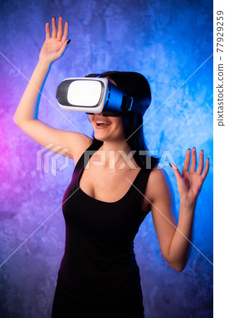 Young teen gamer wearing VR glasses standing and playing virtual reality game Young teen gamer wearing VR glasses standing and playing virtual reality game 77929259
