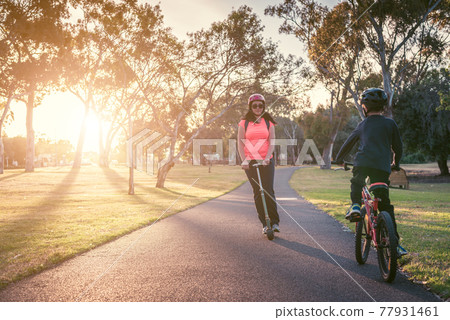 Mother with her son riding riding in the park 77931461