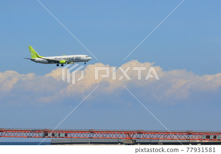Passenger plane landing against the background of summer sky Landing against the background of blue sky 77931581