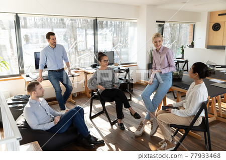 Diverse colleagues involved in briefing, sitting in circle, discussing project Diverse colleagues involved in briefing, sitting in circle, discussing project 77933468