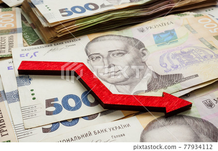 Financial crisis and inflation in Ukraine. Ukrainian money hryvnia and down arrow. 77934112