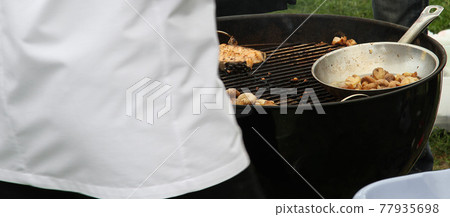 Cook roasts fish meat and grilled mushrooms on the street 77935698