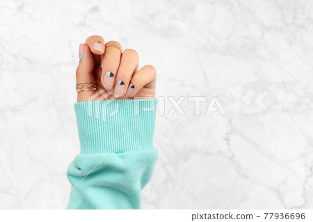 Beautiful groomed womans hand with nude and blue matte nail design Beautiful groomed womans hand with nude and blue matte nail design 77936696