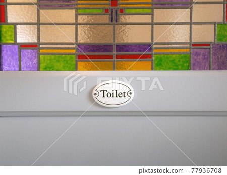 Gray wooden door with Toilet sign text and colorful stained glass in building, closeup background texture modern design Gray wooden door with Toilet sign text and colorful stained glass in building, closeup background texture modern design 77936708