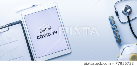 Quarantine is over. Syringe with needle, hospital healthcare charts, doctor stethoscope and white tablet with text on screen for medical equipment background. End of covid concept. 77936738