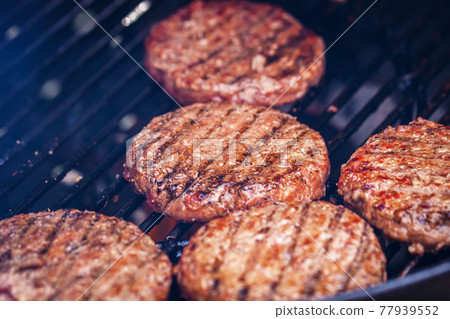 Beef burgers for hamburger on metal barbecue grill close-up, BBQ day 77939552