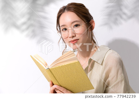 Portrait of a young woman reading 77942239