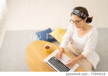 Young woman using a personal computer Young woman using a personal computer 77944018