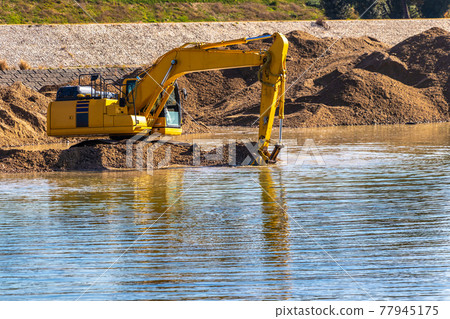 舀起河床上的泥土和沙子的防洪挖掘機 77945175