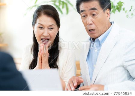 Middle-aged couple having business talks with sales staff Middle-aged couple having business talks with sales staff 77945924