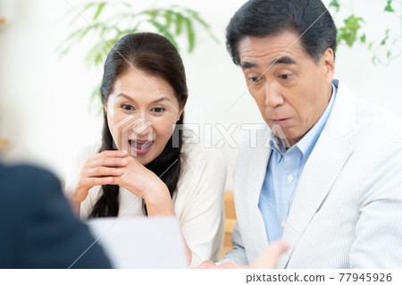 Middle-aged couple having business talks with sales staff Middle-aged couple having business talks with sales staff 77945926