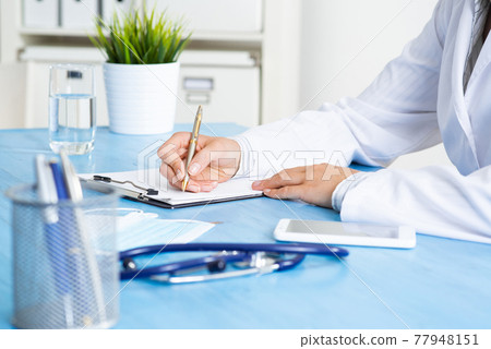 Doctor filling patient history list at clipboard Doctor filling patient history list at clipboard 77948151