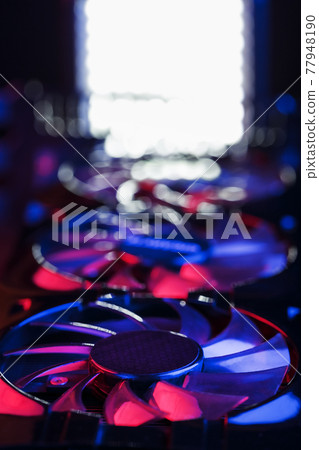 Large and powerful graphics card with three fans with blue pink light. Large and powerful graphics card with three fans with blue pink light. 77948190