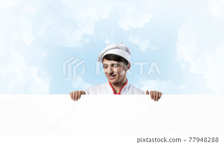 Young male chef with blank signboard Young male chef with blank signboard 77948288