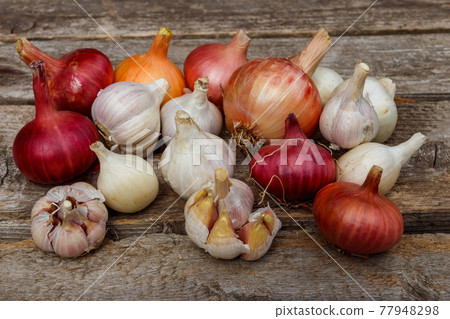 Fresh garlic and onion on a rustic wooden table Fresh garlic and onion on a rustic wooden table 77948298