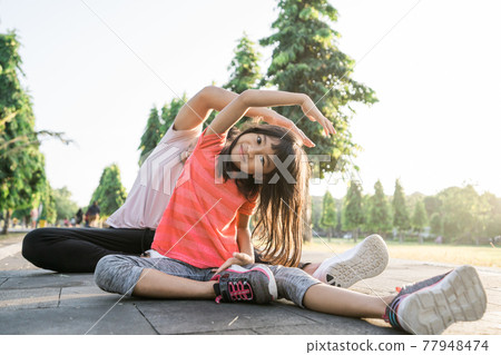 father and little daughter do exercises in outdoor. Healthy lifestyle of family with child 77948474