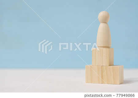 Abstract wooden figure of man on toy blocks are located as podium. Abstract wooden figure of man on toy blocks are located as podium. 77949866