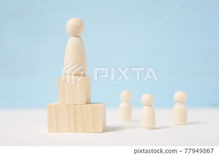 Figure of man on blocks are located as podium and people beside him. 77949867