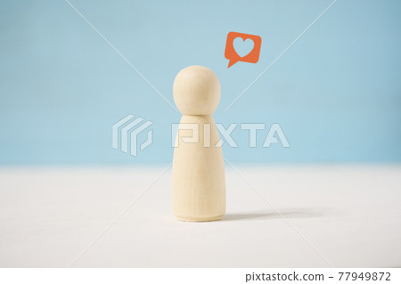 Wooden figure of man with painted message with heart. Concept of love letter. 77949872