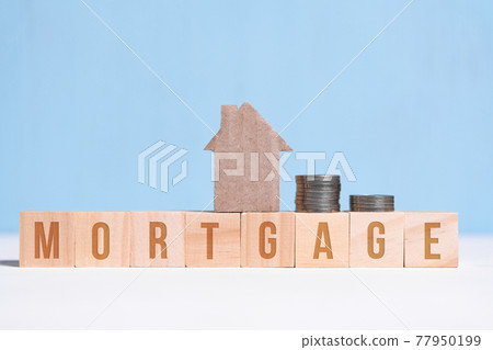 Cardboard cutout house and coins on cubes with inscription mortgage on blue background. Cardboard cutout house and coins on cubes with inscription mortgage on blue background. 77950199