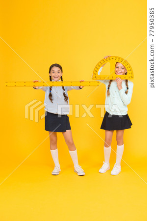 Learning school geometry. School children with measuring instruments on yellow background. 77950385