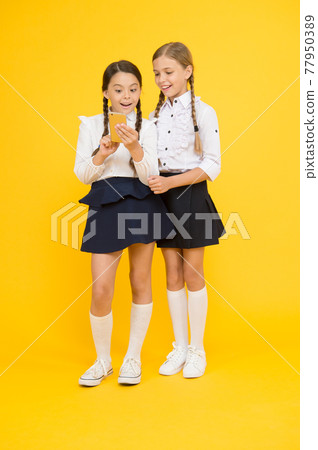 Girls school uniform using smartphone. Schoolgirls Girls school uniform using smartphone. Schoolgirls 77950389