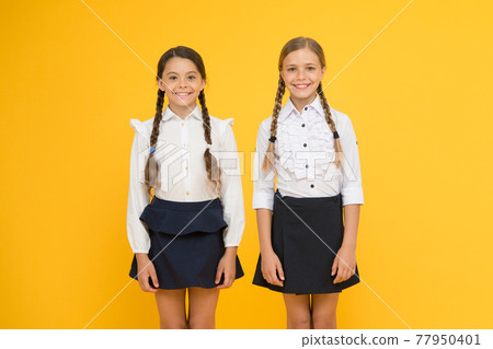 Building a brighter future for children. Cute little schoolgirls happy smiling on yellow background. Building a brighter future for children. Cute little schoolgirls happy smiling on yellow background. 77950401