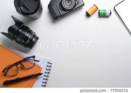 Camera accessories, notebook and copy space on photographer workplace. Camera accessories, notebook and copy space on photographer workplace. 77950558