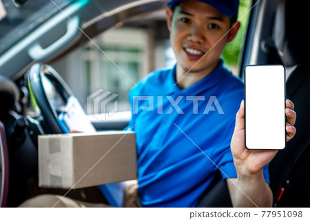 Asian deliveryman staff show mobile phone and preparing packages to deliver to customers who order online during the coronavirus or covid-19 outbreak. Asian deliveryman staff show mobile phone and preparing packages to deliver to customers who order online during the coronavirus or covid-19 outbreak. 77951098