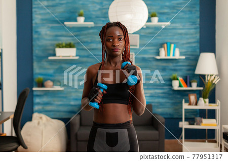 Athletic fit strong black woman working out with with dumbbells 77951317