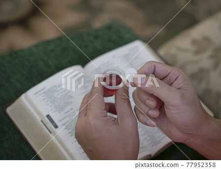 Man holding bread and wine in Hoy Communion. Man holding bread and wine in Hoy Communion. 77952358