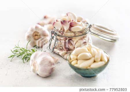 Garlic concept consisting of a jar full of lovely aromatic garlic cloves Garlic concept consisting of a jar full of lovely aromatic garlic cloves 77952803
