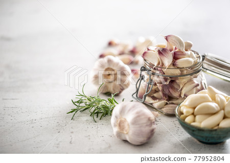 Garlic concept consisting of a jar full of lovely aromatic garlic cloves Garlic concept consisting of a jar full of lovely aromatic garlic cloves 77952804