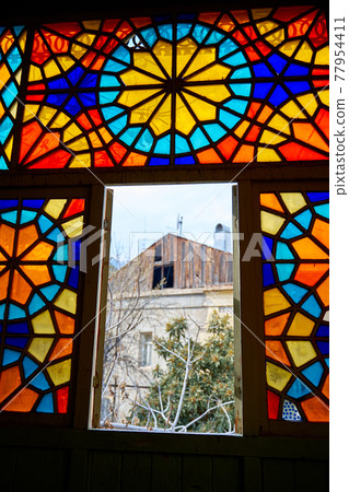 Authentic balcony of an old residential building with a stained glass window made of multicolored mosaics Authentic balcony of an old residential building with a stained glass window made of multicolored mosaics 77954411