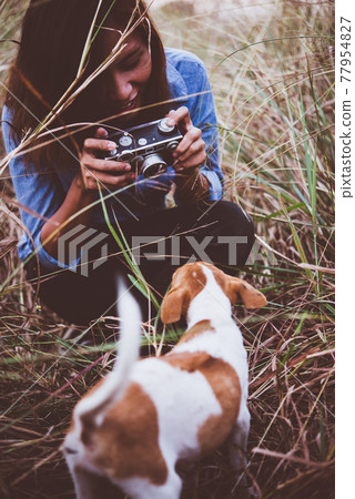 Shot of hipster woman taking a snapshot of her dog on her vintage camera. Shot of hipster woman taking a snapshot of her dog on her vintage camera. 77954827