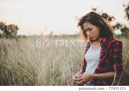 Close up of lonely woman alone in a field. Vintage filter style. Close up of lonely woman alone in a field. Vintage filter style. 77955155