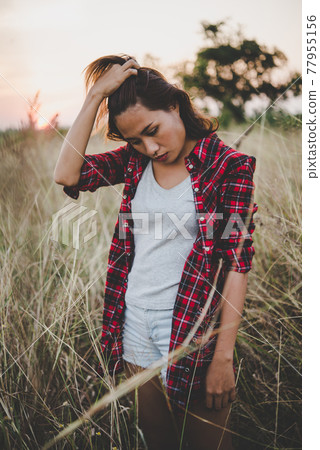 Close up of lonely woman alone in a field. Vintage filter style. 77955156