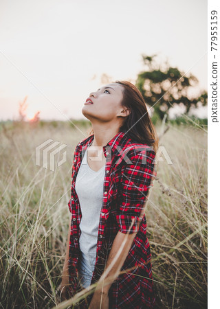 Close up of lonely woman alone in a field. Vintage filter style. Close up of lonely woman alone in a field. Vintage filter style. 77955159