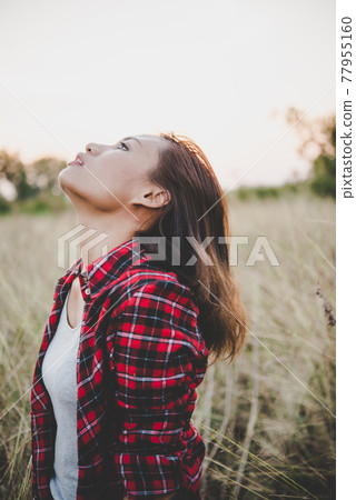 Close up of lonely woman alone in a field. Vintage filter style. 77955160