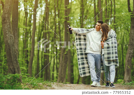 Beautiful couple spend time in a spring forest Beautiful couple spend time in a spring forest 77955352