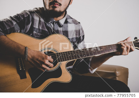 Close up of hipster beard man hand playing guitar. 77955705