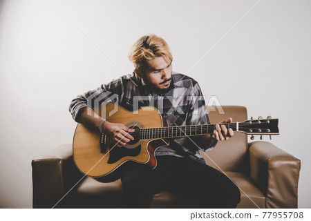 Close up of hipster beard man hand playing guitar. Close up of hipster beard man hand playing guitar. 77955708