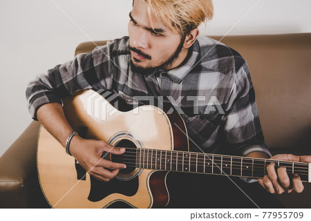 Close up of hipster beard man hand playing guitar. Close up of hipster beard man hand playing guitar. 77955709